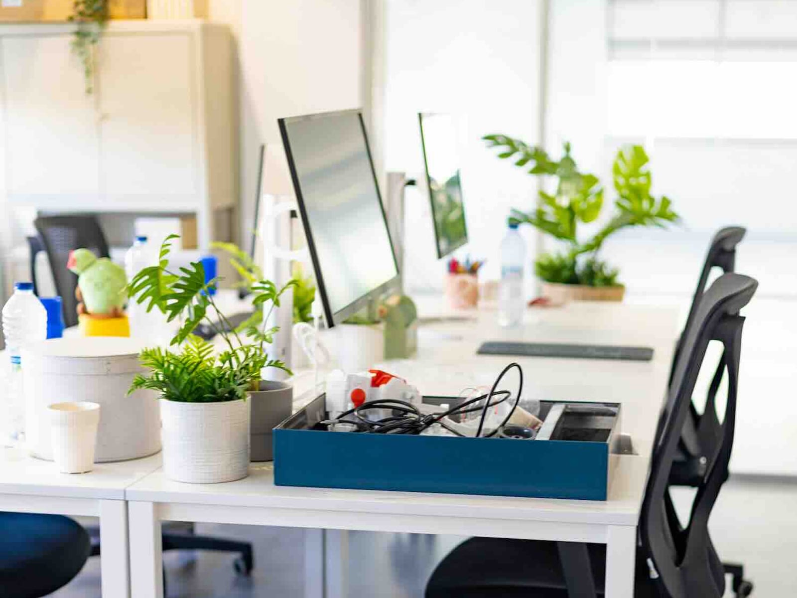 Puesto fijo de coworking con las cosas personales de su usuario sobre la mesa.